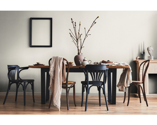 Lichte eetkamer met houten tafel, stoelen en decoratieve elementen voor een gezellige sfeer.