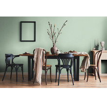 Eetkamer met houten tafel, stoelen en decoraties in een lichte ruimte.
