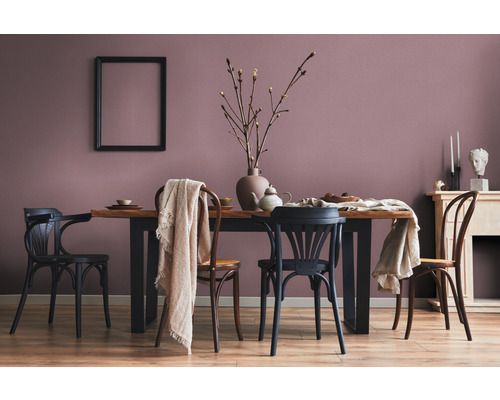 Eetkamer met houten tafel, stoelen, decoratie en fotolijst aan de muur