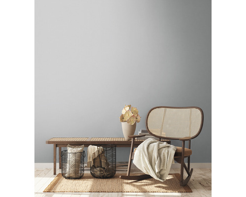 Woonkamer met houten bank, rotan schommelstoel en decoraties