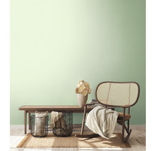 Lichte, vriendelijke inrichting met een bank, rotan stoel, manden en decoratie op een vloerkleed.
