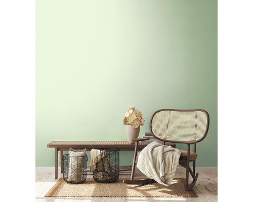 Lichte, vriendelijke inrichting met een bank, rotan stoel, manden en decoratie op een vloerkleed.