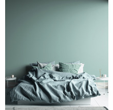 Slaapkamer met bed, kussens en nachtkastjes.