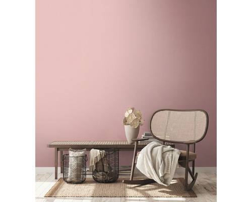 Woonkamer met rotan stoel, bank, manden en decoratieve elementen voor een gezellige sfeer