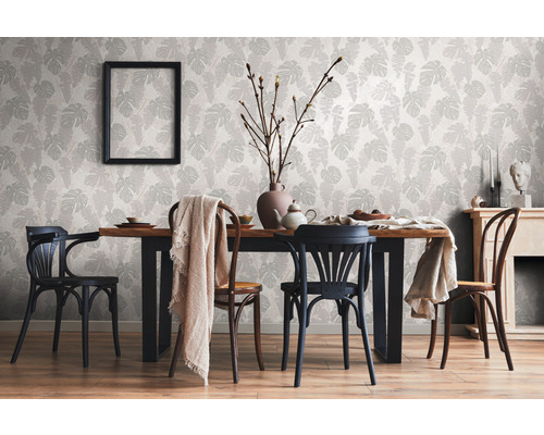 Eetkamer met eettafel, stoelen en behang versierd met bladeren