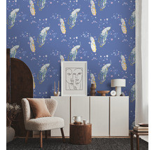Een woonkamer met bloemenbehang, een fauteuil en een witte kast.