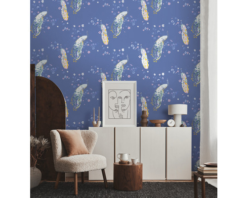 Een woonkamer met bloemenbehang, een fauteuil en een witte kast.