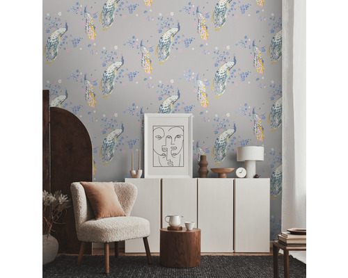 Lichte kamer met behang met pauwpatroon, fauteuil, dressoir en decoraties voor een huiselijke sfeer.