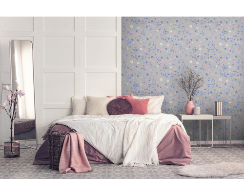 Slaapkamer met bed, spiegel en bloemenbehang voor een gezellige sfeer.