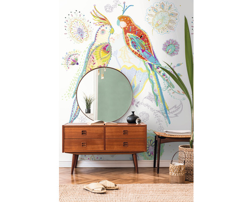 Decoratief behang met papegaaienmotief boven een houten dressoir met spiegel