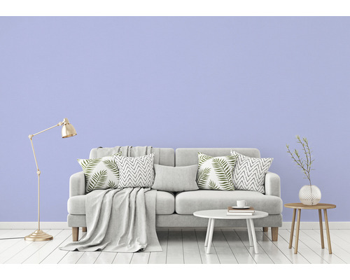 Woonkamer met grijze bank, kussens, deken, tafel, vloerlamp en decoratie