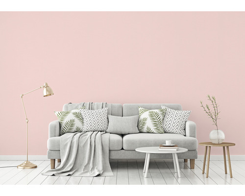 Woonkamer scène met bank, kussens, deken, lamp en bijzettafels.