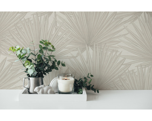 Close-up van behang met patroon, planten en kaars op een tafel.