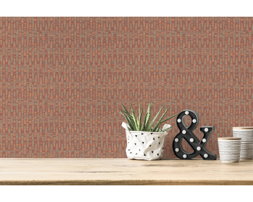 Close-up van een muur met een behang met rechtlijnig patroon, versierd met een kamerplant, een verlichte ampersandfiguur en twee bekers op een houten oppervlak.