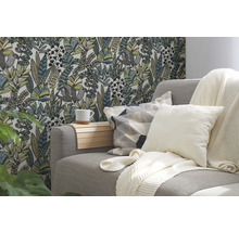 Woonkamer met bank, kussens, deken en bloemenbehang
