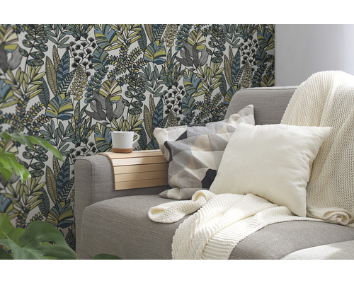 Woonkamer met bank, kussens, deken en bloemenbehang