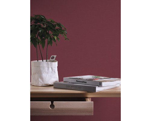 Decoratieve opstelling met kamerplant in papieren wikkel, boeken en houten bureau