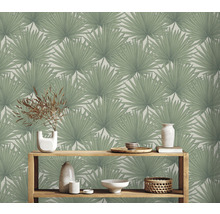 Woonkamer met palmblad behang en houten rek met decoratie
