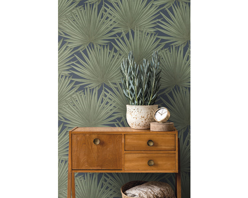 Kamerbeeld met botanisch bladbehang, houten dressoir, potplant en klok.