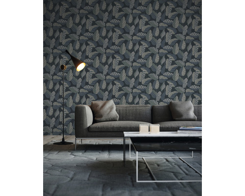 Woonkamer met een behang met bladerpatroon achter een bank