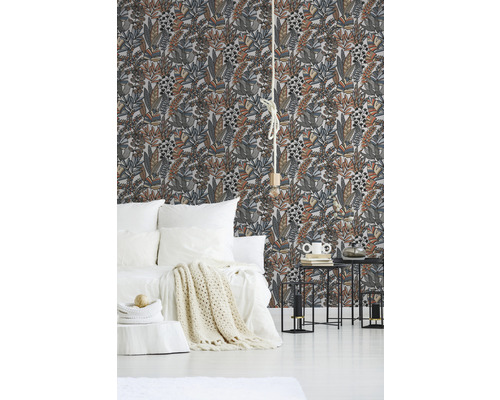 Slaapkamer met bloemenbehang, bed en bijzettafels.