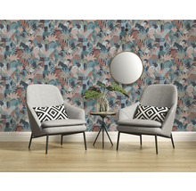 Woonkamer met bloemenbehang, twee grijze fauteuils en een ronde spiegel