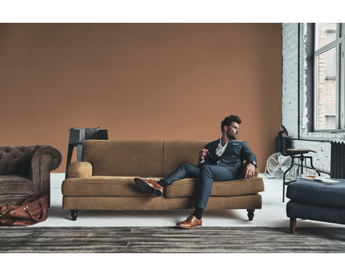 Een man in een pak ontspant op een bank in een woonkamer.