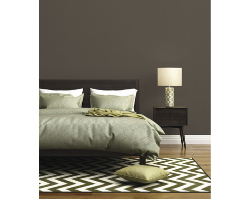 Slaapkamer met bed, nachtkastlamp en zigzag tapijt