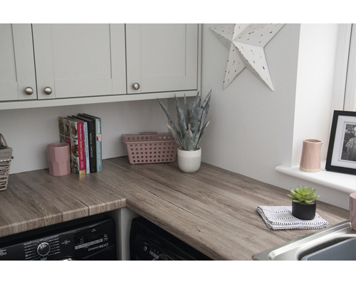 Wasruimte met houten werkblad, wasmachines en keukenkasten