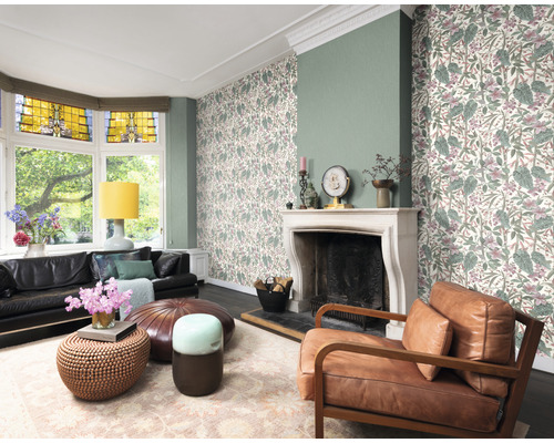 Woonkamer met bank, fauteuil, salontafels, vloerkleed, open haard en behang met plantenmotief