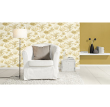 Woonkamer met fauteuil, staande lamp en behang met plantenmotief