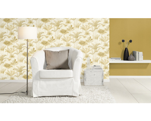 Woonkamer met fauteuil, staande lamp en behang met plantenmotief