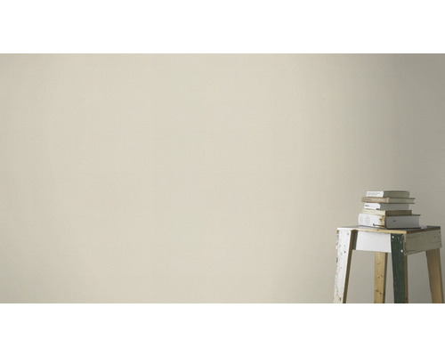 Lichte muurverf in interieur met stapel boeken op een kruk