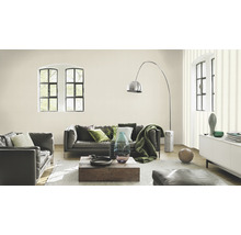 Woonkamer met grijze leren bank, houten tafel en decoratieve elementen.