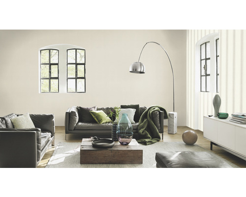 Woonkamer met grijze leren bank, houten tafel en decoratieve elementen.