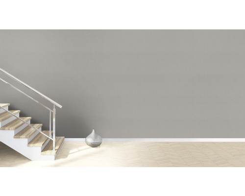 Lichte kamer met trap, zilveren vaas en parketvloer.