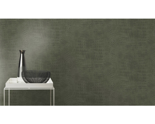 Close-up van een muur met behang in krokodillenleer, met een tafel waarop een vaas staat