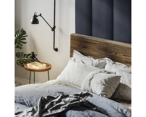 Slaapkamer met houten bedframe, nachtkastje, leeslamp en decoratie