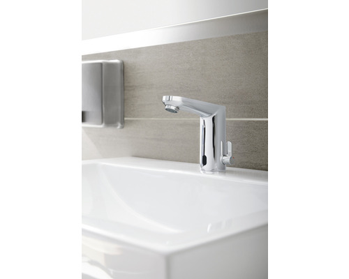 Wastafelkraan van metaal op een witte wastafel