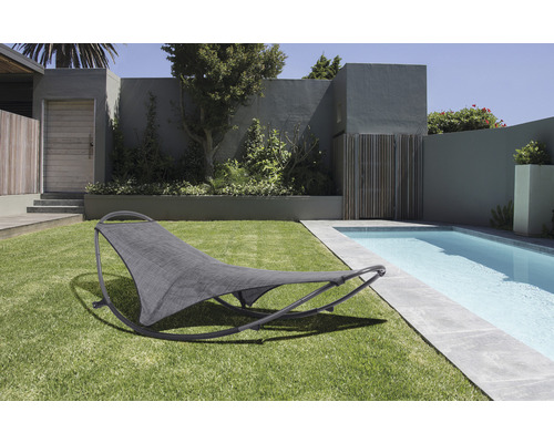 Tuinscene met gazon en zwembad, op de voorgrond een grijze schommelstoel