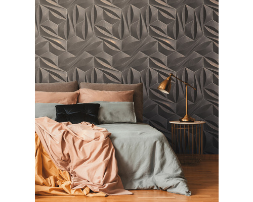 Slaapkamer met driedimensionaal wanddesign achter een bed en een nachtkastje met lamp