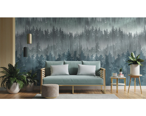 Woonkamer met bank voor een behang met bosmotief.