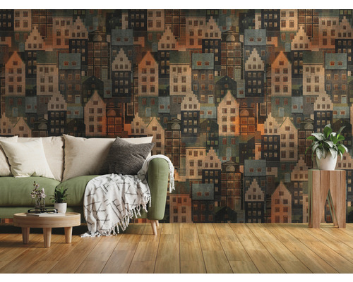 Woonkamer met groene bank en behang met huizenmotief