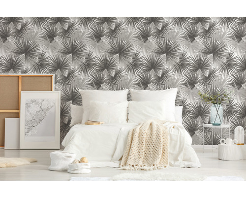 Slaapkamer met patroonbehang, bed en decoratieve artikelen voor een gezellige sfeer.