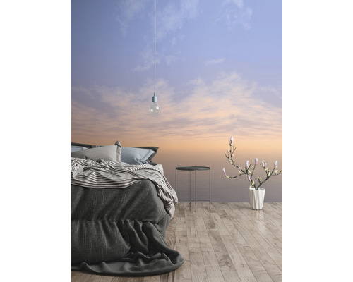 Slaapkamer met bed, bijzettafel, bloemenvaas en behang met hemelthema