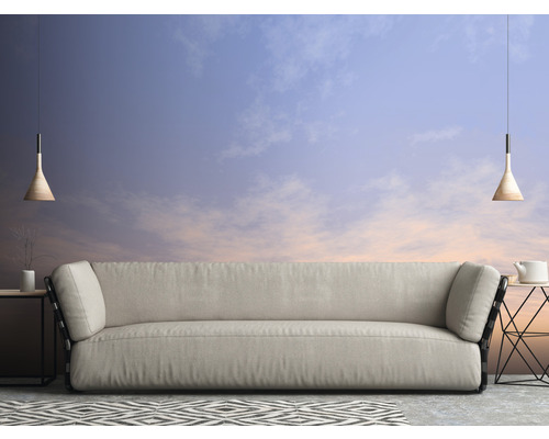 Woonkamer met bank, bijzettafels, hanglampen en een vloerkleed met motief