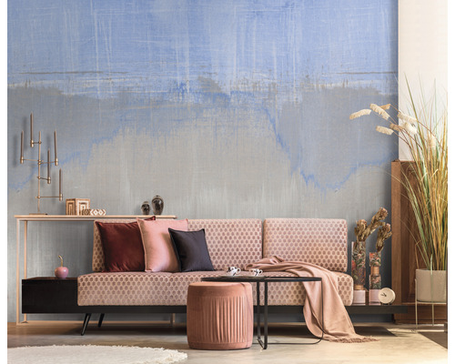 Woonkamer met patroonbehang, bank, hocker en decoratie