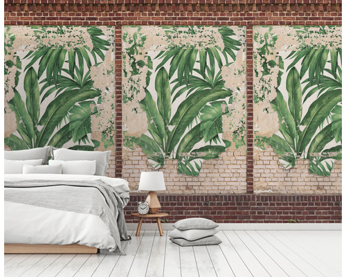 Wanddecoratie met tropisch bladerenmotief in een kamer met bed en bakstenen muur