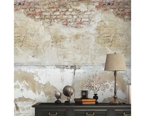 Decoratief interieur met dressoir, lamp en een muur met stuc- en baksteenelementen.