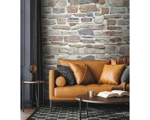 Woonkamer met bank, kussens, tafel en steenwandbehang